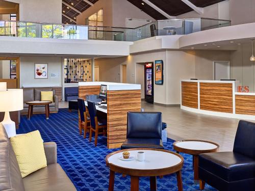 a lobby with chairs and tables and a bar at Sonesta Simply Suites Memphis East Poplar Pike in Memphis