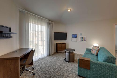 a living room with a couch and a desk at Sonesta ES Suites Sunnyvale in Sunnyvale