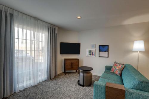 a living room with a couch and a flat screen tv at Sonesta ES Suites Sunnyvale in Sunnyvale