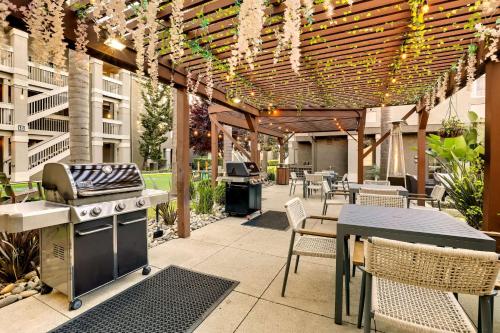 an outdoor patio with a grill and tables and chairs at Sonesta ES Suites Sunnyvale in Sunnyvale