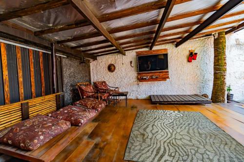 a living room with a couch and a tv at Pousada Maré Alta - Maresias - 350mt da praia in Maresias
