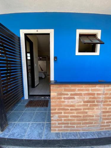 a building with a blue wall and a doorway at Pousada Maré Alta - Maresias - 350mt da praia in Maresias