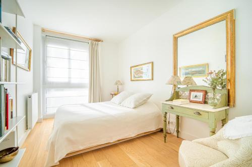 - une chambre avec un lit et une table avec un miroir dans l'établissement Lovely apartment with view, à Paris
