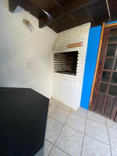 a room with a brick fireplace next to a door at Pousada Maré Alta - Maresias - 350mt da praia in Maresias