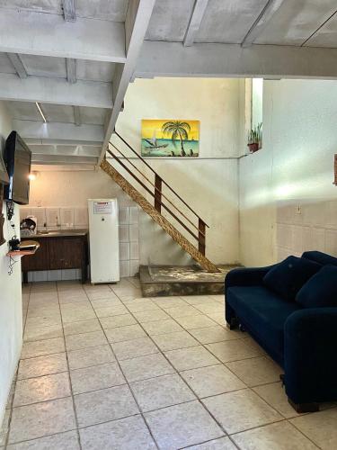 a living room with a blue couch and a staircase at Pousada Maré Alta - Maresias - 350mt da praia in Maresias