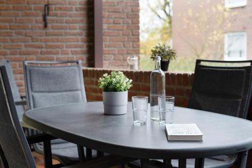 a table with a bottle of wine and glasses at Waldstraße 4 Waldkoje in Kellenhusen