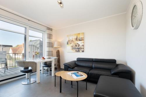 a living room with a couch and a table at Strandresidenz Vogelflug App 12 in Fehmarnsund