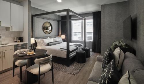 a bedroom with a bed and a table and a kitchen at Luxury Apartments by Hyatus Center City in Philadelphia