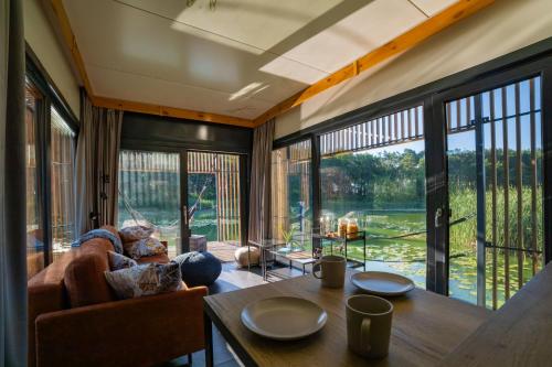 a living room with a couch and a table at Water Hideout - Floating Villas in Wild Nature in Nowawieś Zbąska