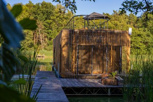 a wooden dock in the middle of a body of water at Water Hideout - Floating Villas in Wild Nature in Nowawieś Zbąska