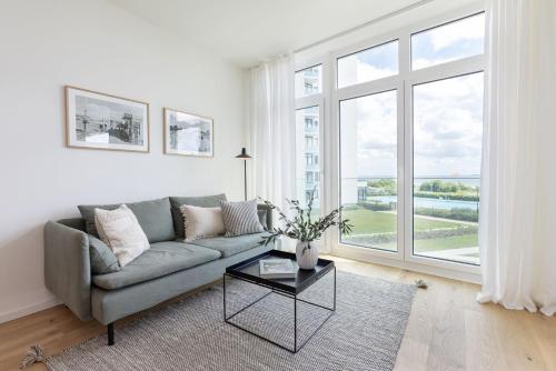a living room with a couch and a large window at Eichenhain Saltkrokan in Pelzerhaken