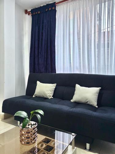 a blue couch in a living room with a window at Posada Guambi VIP in Bogotá