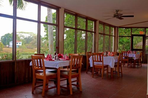 Burrell Boom黑兰花度假村酒店的餐厅里有桌椅和窗户。