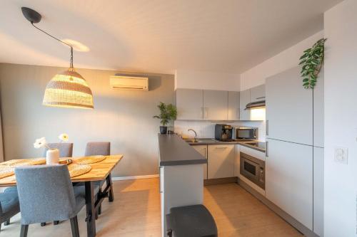 Una cocina y un comedor con mesa y sillas. en Estrella del Mar III, en Ostende