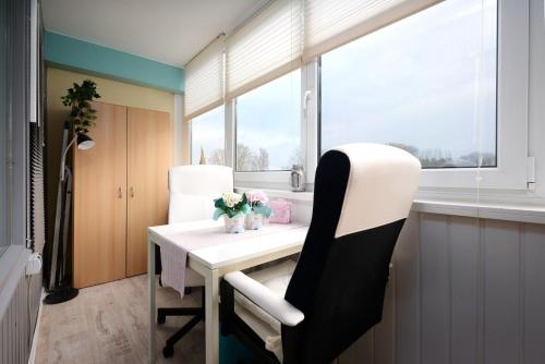 ブラズィリアンにあるMien Leevの白いテーブルと椅子、窓が備わる客室です。