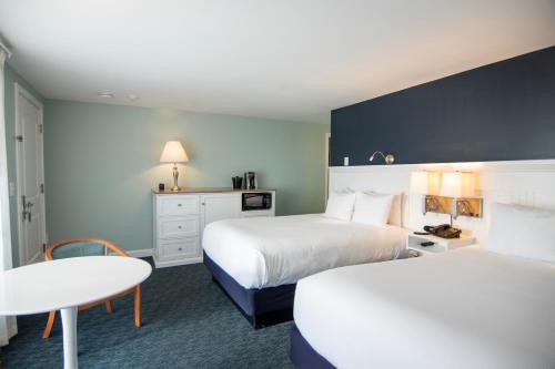 a hotel room with two beds and a table at Cape Colony Inn in Provincetown