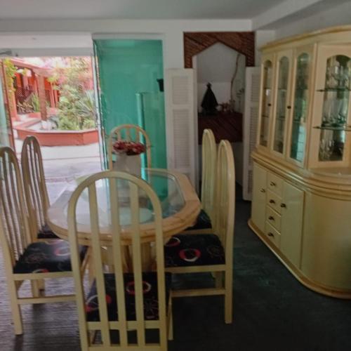 a dining room with a table and chairs and a cabinet at Pousada Gaivotas do Guaraú in Peruíbe