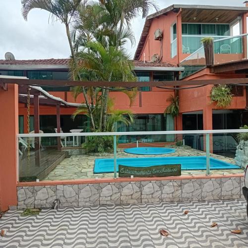 a resort with a swimming pool in front of a building at Pousada Gaivotas do Guaraú in Peruíbe