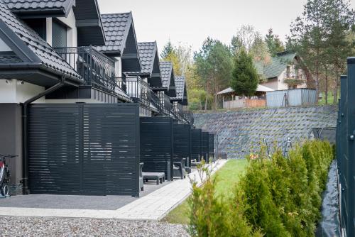 a building with black gates and a stone wall at Zacisze Deluxe - Apartamenty in Krościenko