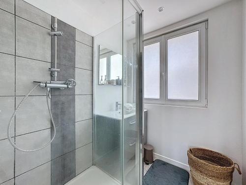 une salle de bain avec une douche en verre avec une fenêtre dans l'établissement Appartement 6 personnes - Garage wilson, à Clermont-Ferrand
