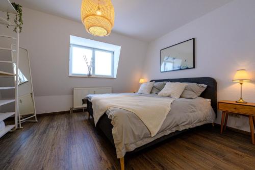 a bedroom with a bed and two windows at Ferienwohnung mit Sonnenbalkon & Parkplatz in Neustadt an der Weinstraße