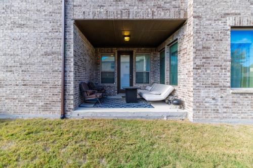 a brick building with a porch with two chairs at Modern Allen Prairie Retreat in Allen
