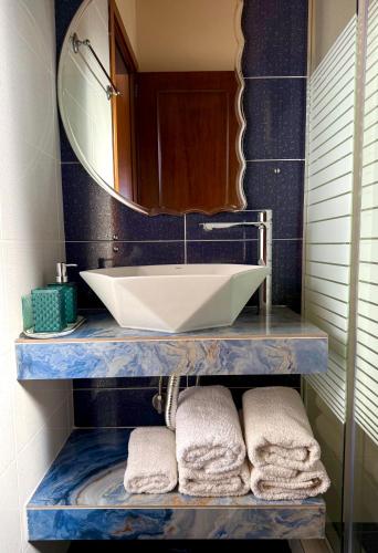 a bathroom with a sink and a mirror and towels at Driopes Villas in Koroni