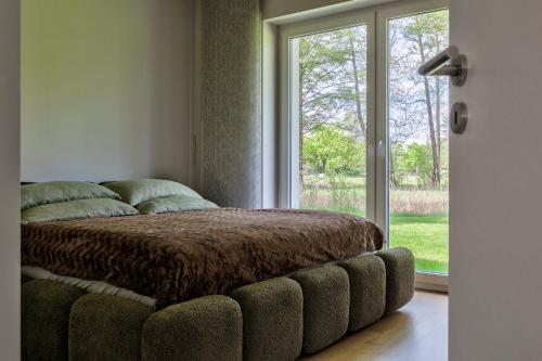 a bed in a room with a large window at Apartment Rehwiese in Burg