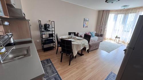 a kitchen and living room with a table and a couch at Nancy Sea View Apartment in Sveti Vlas