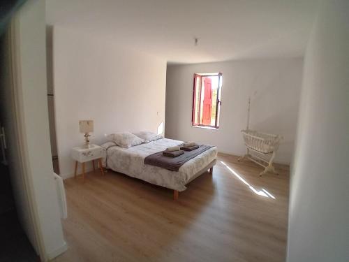 une chambre blanche avec un lit et une fenêtre dans l'établissement Appartement neuf dans domaine viticole, à Montagnac