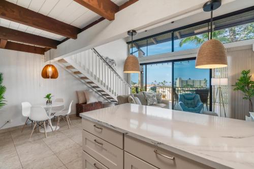een keuken en woonkamer met een tafel en stoelen bij Perch - Alii Kai Loft in Kihei
