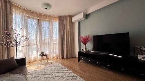 a living room with a flat screen tv on a wall at Nancy Sea View Apartment in Sveti Vlas