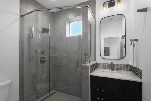a bathroom with a glass shower and a sink at Surf and City by Gulf Coast Getaways in Pensacola Beach