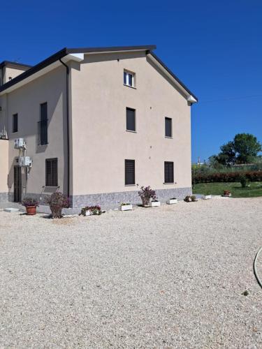 a large white building on a gravel driveway at Casa Vacanze APPARTAMENTO NONNA SILVANA in Atessa
