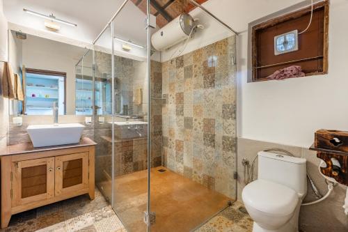 Un baño con inodoro, lavabo y ducha. en Sliceinn Somewhere Together In Biligeri, en Madikeri