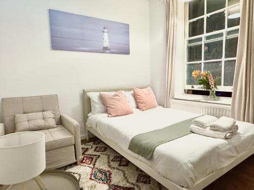 a bedroom with a bed and a chair and a lighthouse at Shoreditch Rooms Near Tower Bridge in London