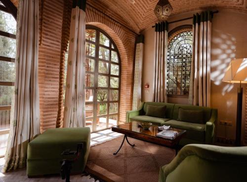 a living room with a green couch and a table at Olinto, Atlas Mountain Retreat - adults only in Ouirgane