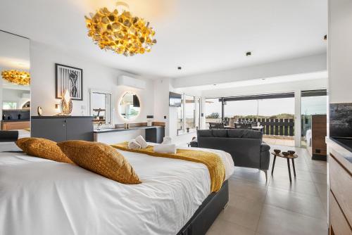 une chambre avec un grand lit et un salon dans l'établissement Village Naturiste R4N - Villa Aurora Sea View, au Cap d'Agde