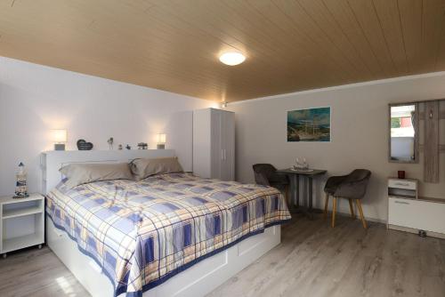 une chambre avec un lit et une table avec une chaise dans l'établissement Leuchtturm Dreangel, à Heikendorf