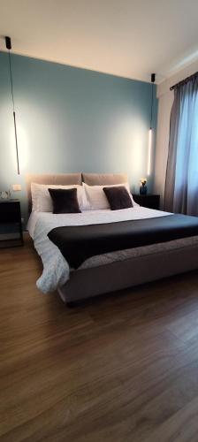 a bedroom with a large bed with a blue wall at HOLIDAYS HOMES ROME GOLF Appartamenti Marco Simone AeB in Marco Simone