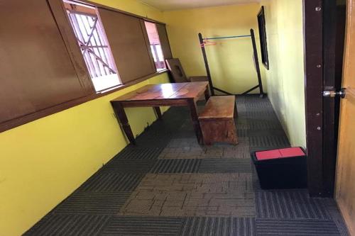 ein leeres Zimmer mit einem Holztisch und einem Fenster in der Unterkunft Luis Bay Travellers Lodge Coron in Coron