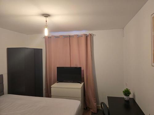 a small bedroom with a bed and a television at Furnished double room in Rowley Regis