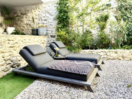 a reclining chair sitting on a gravel patio at L'oiseau Bleu suite MERLE BLEU in Roubia