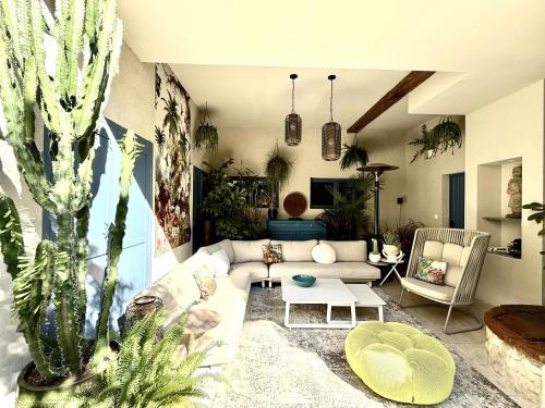 a living room with a couch and some plants at L'oiseau Bleu suite MERLE BLEU in Roubia
