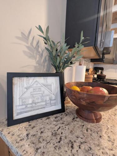 a bowl of fruit on a counter with a picture of a house at Walking Distance to the Beach Cabin with AC in Arrowhead Lake