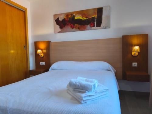 a hotel room with a bed with towels on it at Enebrales 423 in Punta Umbría