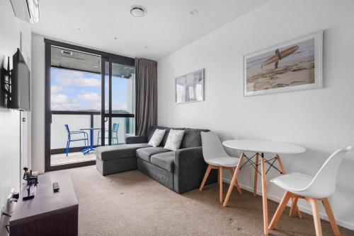 a living room with a couch and a table at Neighborhood Hideaway with Air-con and Deck in Auckland