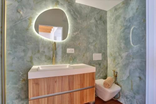 a bathroom with a sink and a mirror and a toilet at Penthouse in El Cotillo in Cotillo