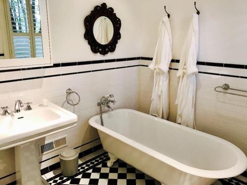 a bathroom with a white tub and a sink at Mirrabella Blue Mountains Boutique Getaway in Blackheath