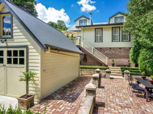 a house with a garage and a patio at Mirrabella Blue Mountains Boutique Getaway in Blackheath